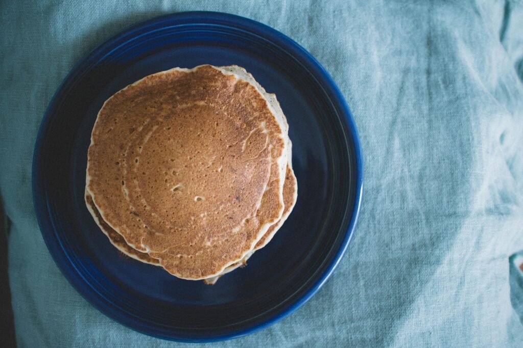 Aerial view of homemade pancakes on a blue plate, ready for breakfast.